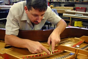 Franco Skilan restringing a grand piano